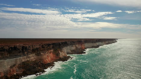 Luftaufnahme-Von-Wellen,-Die-Auf-Steilen-Klippen-Zusammenbrechen,-Schöne-Farbpalette-In-Australien
