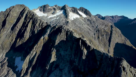 revealing-drone-shot-Milford-Sound-Gertrude-Saddle-Fiordland-National-Park,-New-Zealand-mountains
