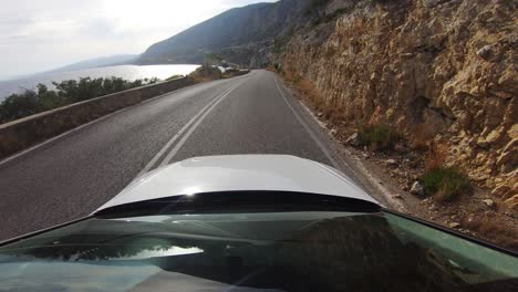 Beautiful-Driver-POV-on-a-coastal-road-of-the-Corinthian-golf-in-Greece-with-bright-sunlight-shine-in-the-seawater