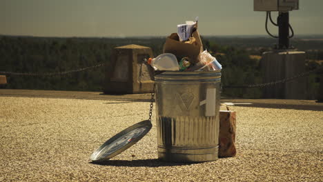 Metal-rubbish-bin-full-with-trash-outside-at-view-point-in-American-nature-park