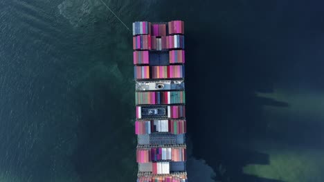 Two-Tugboats-manoeuvring-a-large-empty-Container-Ship-into-Hong-Kong-port,-Aerial-view