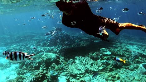 Mann,-Der-Auf-Dem-Blauen-Ozean-Mit-Wunderschönem-Meeresleben-Und-Korallenriffen-Unter-Wasser-Schnorchelt