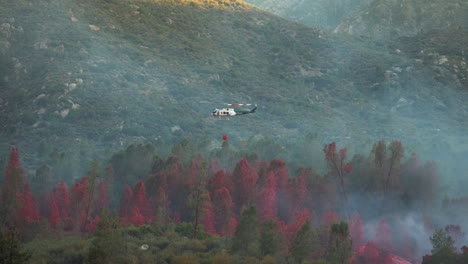 Helicóptero-Arrojando-Retardante-Químico-Rojo-Para-Evitar-La-Propagación-De-Incendios-Forestales