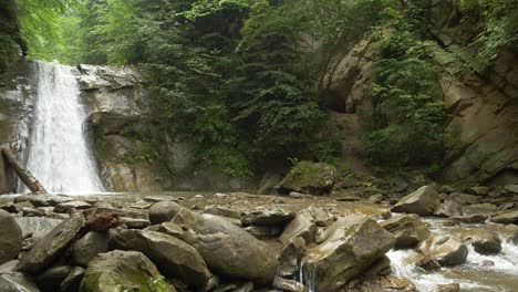 Malerische-Landschaft,-Natürlicher-Wasserfall,-Der-Schnell-Fließt,-Kleine-Klippen-Im-Vordergrund