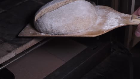 Putting-The-Bread-Dough-Into-The-Oven-With-A-Wooden-Peel