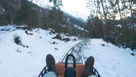 Man-Riding-On-An-Alpine-Coaster-At-The-Chamonix-Amusement-Park-In-France-During-Winter---rolling-shot