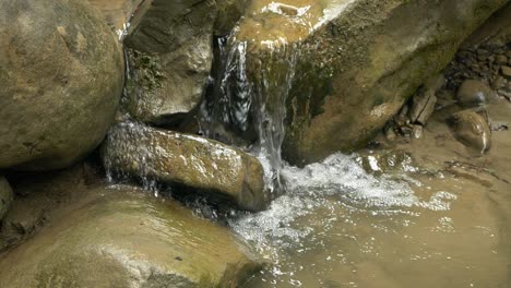 Zeitlupe-Des-Wasserstroms,-Der-über-Abgenutzte-Felsen-Im-Herzen-Eines-Waldes-Fließt
