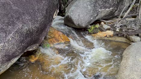 Water-Flowing-In-between-Boulders-At-Emerald-Creek-Falls,-Cairns,-Australia