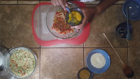 Mixing-eggs-into-a-traditional-recipe-for-homemade-meatloaf---top-down-view
