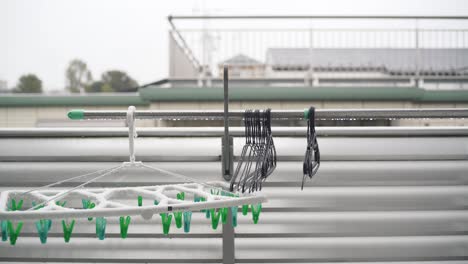 Clothes-Hangers-Wet-In-The-Rain-On-The-Balcony-Of-A-Japanese-Household-In-Tokyo,-Japan