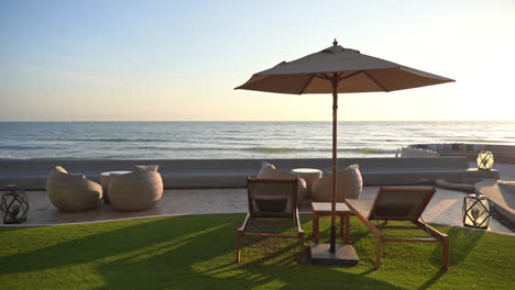 Ruhiger-Sonnenuntergang-Am-Strand-Mit-Liegestühlen-Und-Sonnenschirm-Mit-Blick-Auf-Das-Meer