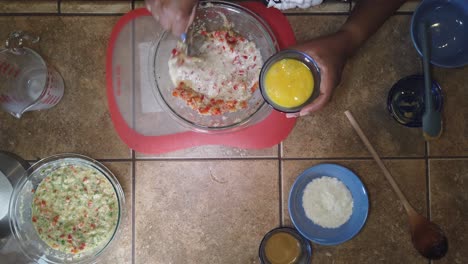 Stirring-milk-and-eggs-into-a-traditional-meatloaf-recipe---top-down-view