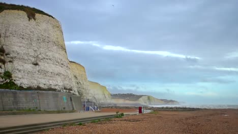 View-along-the-shingle-beach-at-Rottingdean,-England,-along-the-coast-and-the-White-Cliffs-of-Dover