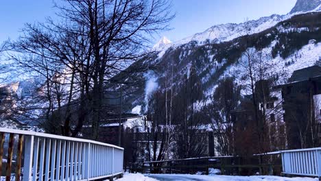 Scenic-View-Of-The-Majestic-Mountain-With-Snow-From-The-Footbridge-In-Chamonix,-France-In-Winter---tilt-up-shot