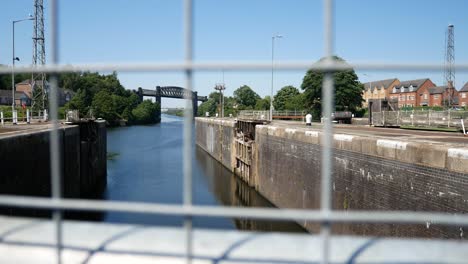 British-canal-channel-waterway-dolly-left-across-wire-fence-railings-shallow-focus