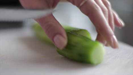Married-Person-Cutting-Cucumber-Twice,-Close-Up