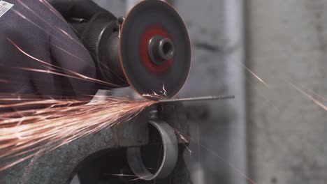 Cutting-metal-element-on-the-vice-with-pneumatic-rotary-cutter-in-the-workshop