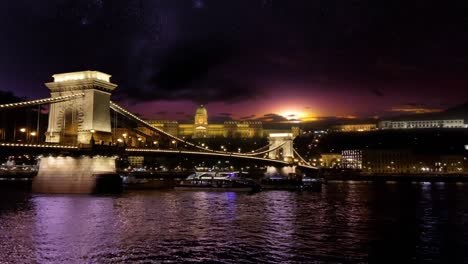 Spectacular-night-view-over-the-Danube,-past-the-Chain-Bridge-towards-Buda-Castle-with-a-dramatic-night-sky