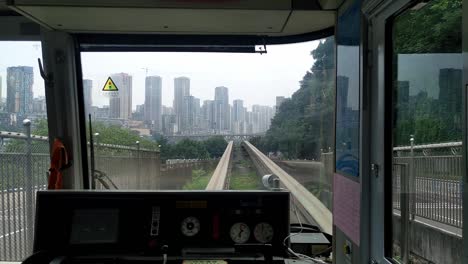 Clip-Desde-El-Interior-De-Un-Tren-tranvía-Sobre-Rieles-Que-Llega-A-Una-Estación-En-La-Ciudad-De-Chongqing-En-China