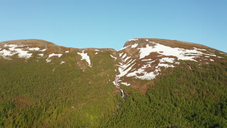 Luftbild-Mit-Blick-Auf-Einen-Wasserfall-Auf-Einem-Schneebedeckten-Berg,-Sonniger-Sommertag,-In-Rotsund,-Troms,-Nordland,-Norwegen---Verfolgung,-Drohnenaufnahme