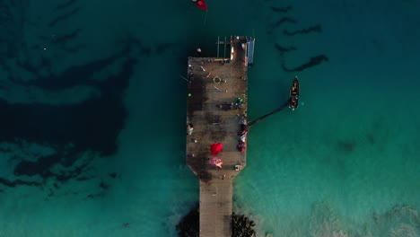 Aerial-top-down-wide-shot-of-the-famous-wooden-pier-at-Santa-Maria,-island-of-Sal,-Cape-Verde