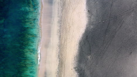 Luftaufnahme-Eines-Leeren-Sandstrandes-Mit-Sanften-Wellen,-Die-Die-Küste-Treffen