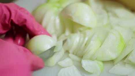 Chopping-fresh-onions-wearing-latex-gloves-closeup