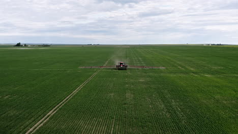 Tractor-Spraying-Wheat-Field-At-Daytime-In-Saskatchewan,-Canada