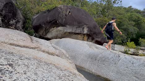 Adult-Male-Walking-Barefoot-and-Jumping-Across-Boulder-At-Emerald-Falls-Creek