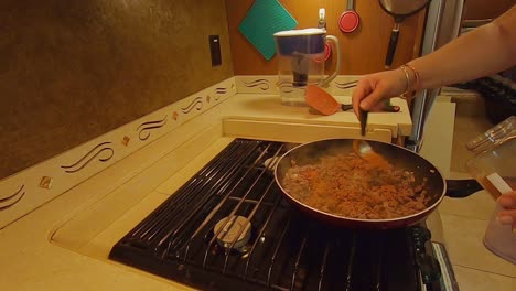 Woman-adding-taco-seasoning-to-cooked-ground-beef