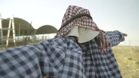 Arabisches-Outfit,-Kafia-Auf-Der-Vogelscheuche,-Hinter-Einem-Schafkäfig-Stehend