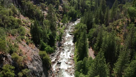 Aerial-descending-shot-of-a-fast-flowing-whitewater-mountain-river