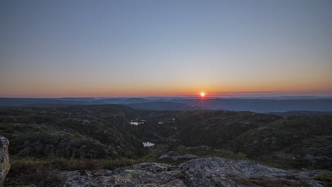 Time-lapse-sun-rises-from-horizon-over-scenic-mountain-wilderness,-Norway