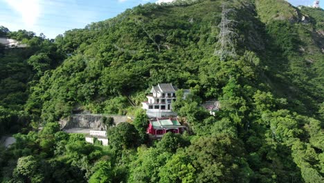 Classic-Temple-in-Hong-Kong,-surrounded-by-lush-green-mountain-terrain,-Aerial-view