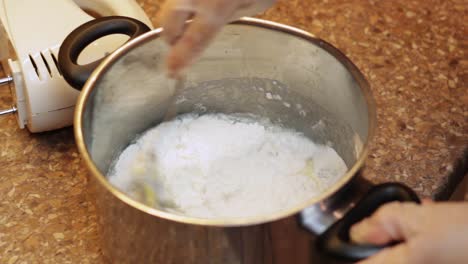 Kochendes-Wasser-In-Einen-Topf-Gießen-Und-Mit-Mehl-Und-Rohen-Eiern-Mischen