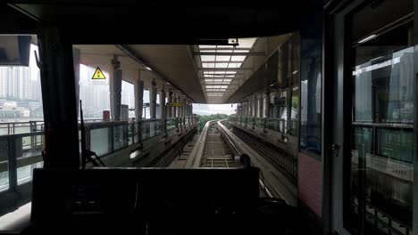 Clip-Desde-El-Interior-De-Un-Tren-Sobre-Raíles-Que-Sale-De-Una-Estación-En-La-Ciudad-De-Chongqing-En-China