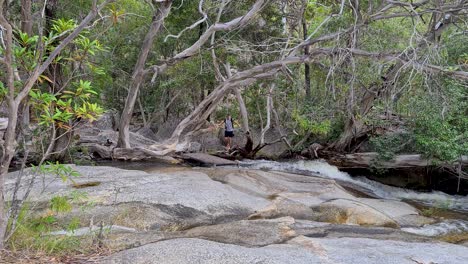 Adult-Male-Carefully-Walking-Barefoot-Across-Rocks-And-Bridge-At-Emerald-Falls-Creek