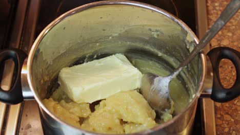 Adding-sticks-of-butter-to-a-saucepan-for-a-boiled-icing