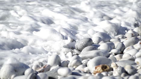 Pebble-Beach-With-Foamy-Sea-Waves-During-SUmmer-In-Greece