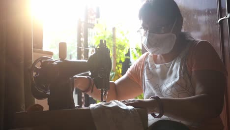 Frau,-Die-Eine-Gesichtsmaske-Auf-Einer-Traditionellen-Manuellen-Nähmaschine-In-Agra,-Bundesstaat-Pradesh,-Indien,-Trägt