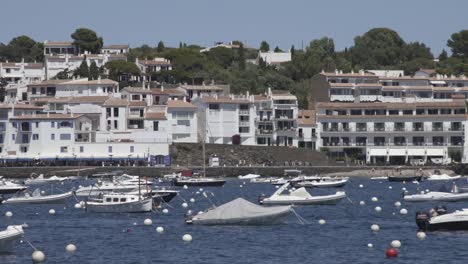 Static-boats-in-coast-town,-white-houses-at-the-background,-Costa-Brava,-Spain