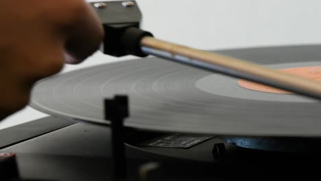 Spinning-vinyl-record-being-switched-off-by-a-woman-hand