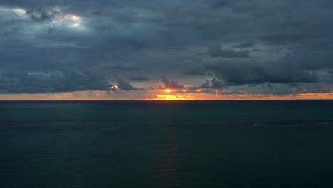 Wunderschöne-Luftdrohne-Aufsteigende-Aufnahme-Eines-Leuchtend-Orangefarbenen-Sonnenaufgangs-Mit-Kleinen-Wellen-Und-Tropischem-Blauem-Ozeanwasser-Und-Darunter-Vom-Well-Beach-In-Der-Nähe-Von-Joao-Pessoa,-Brasilien