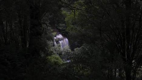 View-of-large-waterfall-from-afar-amongst-rainforest-greenery
