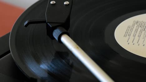 Pickup-arm-lifting-up-from-spinning-vinyl-record-disc