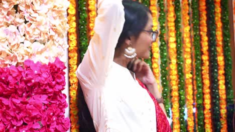 Side-View-Of-Pretty-Indian-Girl-Wearing-Eye-Glasses-And-Big-Earrings-With-Colorful-Garlands-In-Main-Hindu-Festival-'Diwali'-celebration-In-Agra,-India---Medium-Shot