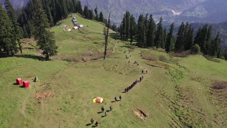 Hikers-Walking-Down-A-Hillside-Trail-In-Sar-Pass---aerial-shot
