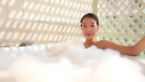 A-pretty-young-woman-relaxed-as-her-bubble-bath-fills-to-the-top