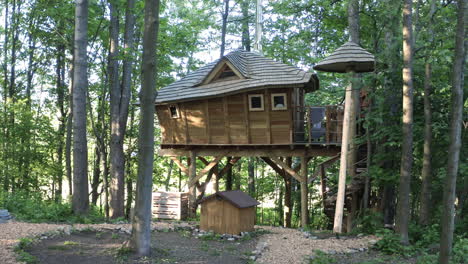 Dolly-4K-Aufnahme-Eines-Luxuriösen-Baumhauses-Aus-Holz-Mit-Einem-Campingplatz-In-Den-Wäldern-Von-Dolní-Morava,-Tschechische-Republik-Im-Sommer-Und-Sonnenstrahlen,-Die-Durch-Die-Bäume-Scheinen