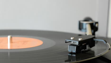 Vinyl-record-player-arm-going-down-on-vinyl-record